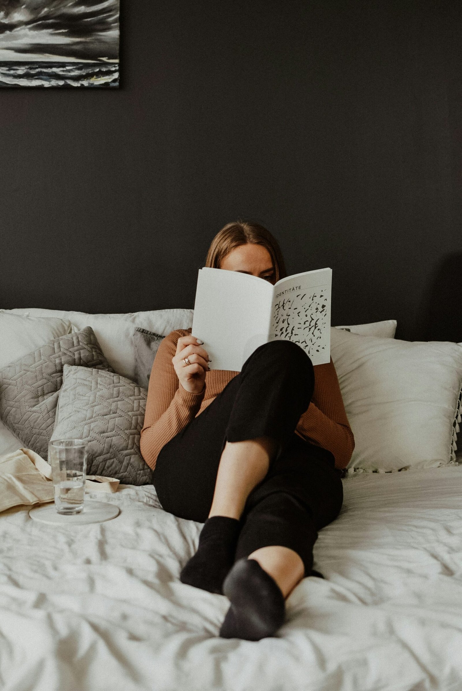 a woman laying on a bed reading a book